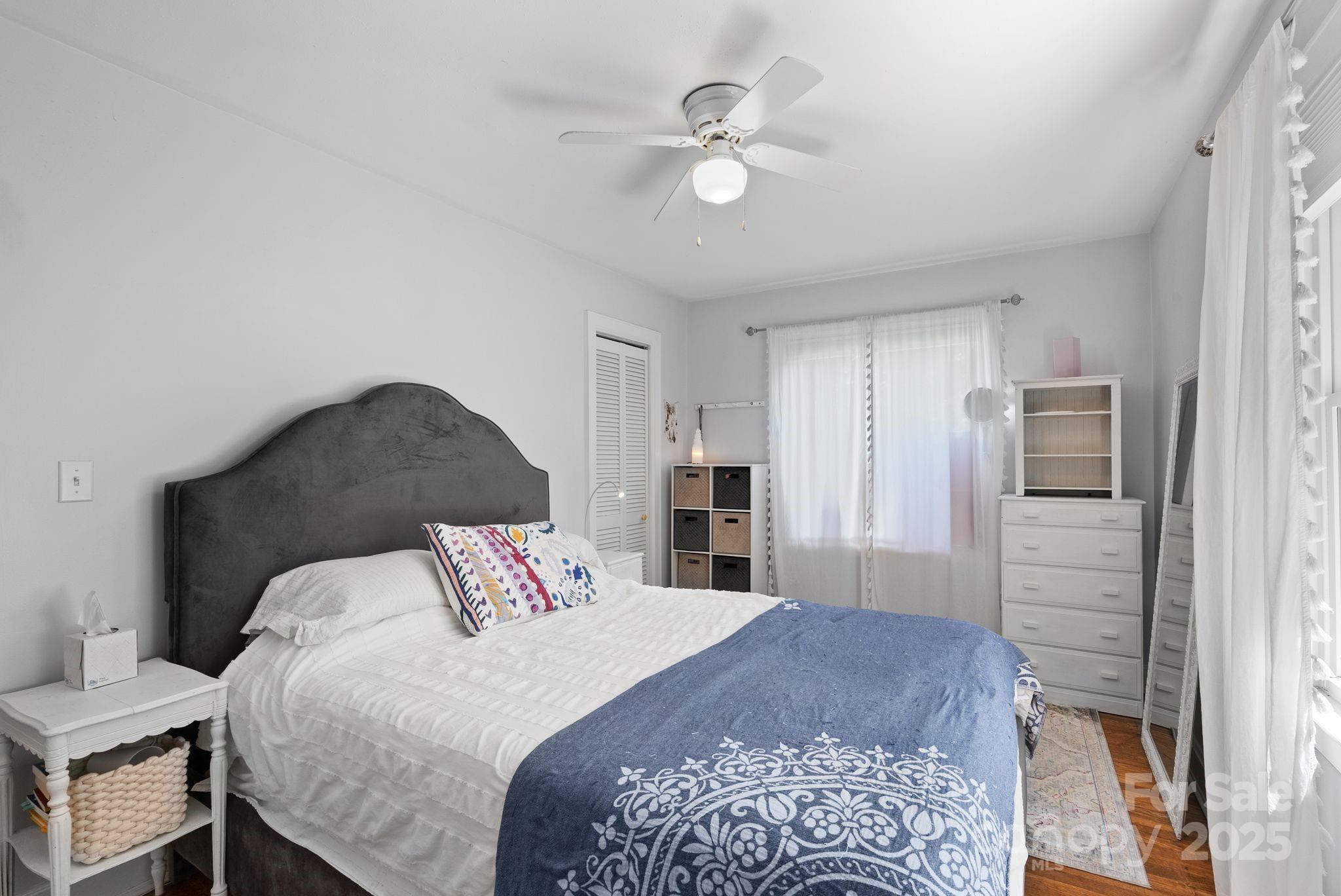 1215 Upper Brush Creek Road Fairview, NC 28730 - Photo 19 of 41 a bedroom with a large bed and a chandelier