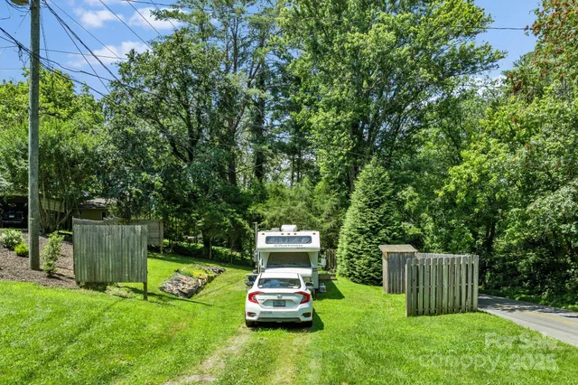 a car parked in the grass near a tree