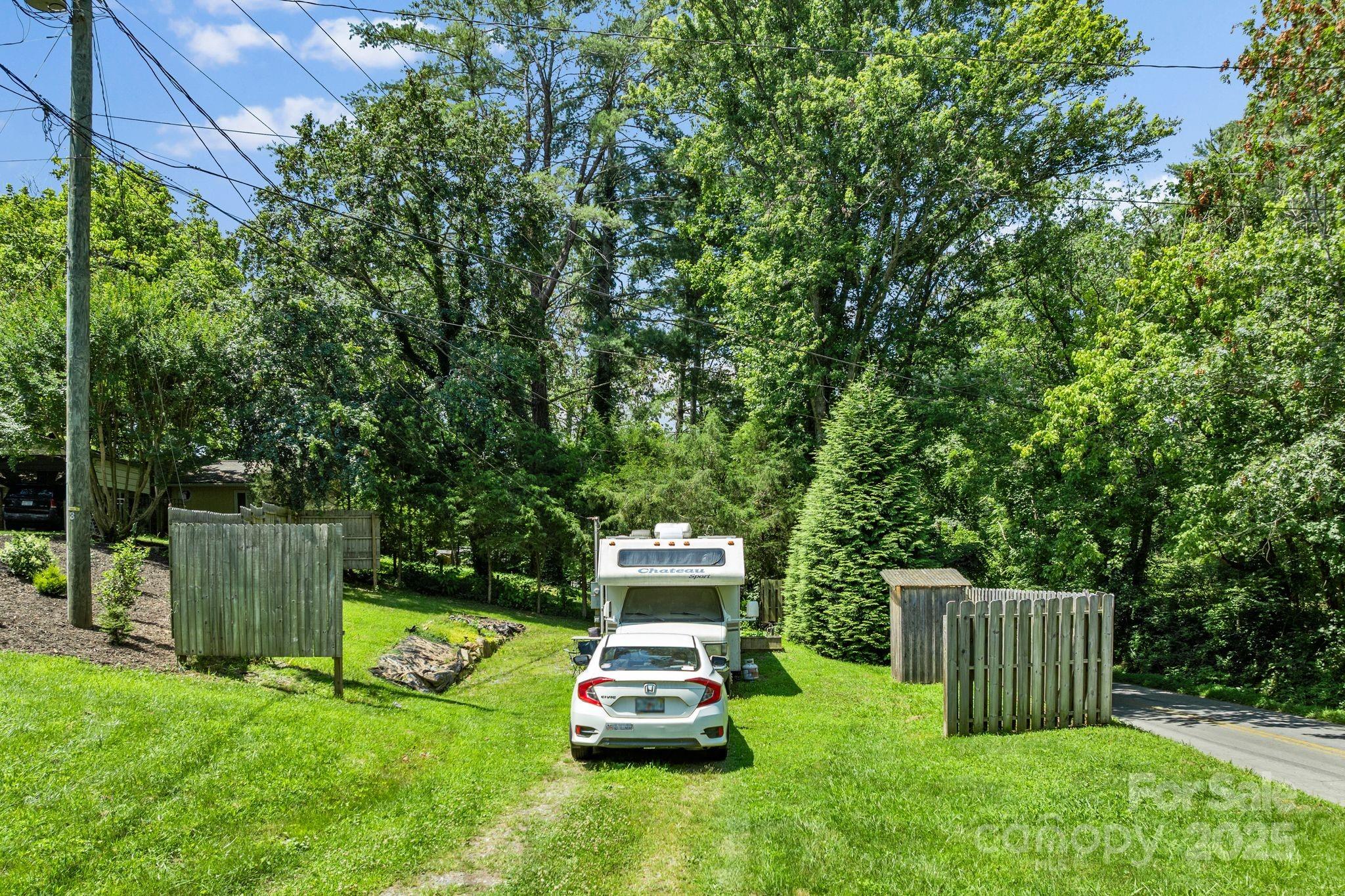 1215 Upper Brush Creek Road Fairview, NC 28730 - Photo 36 of 41 a car parked in the grass near a tree