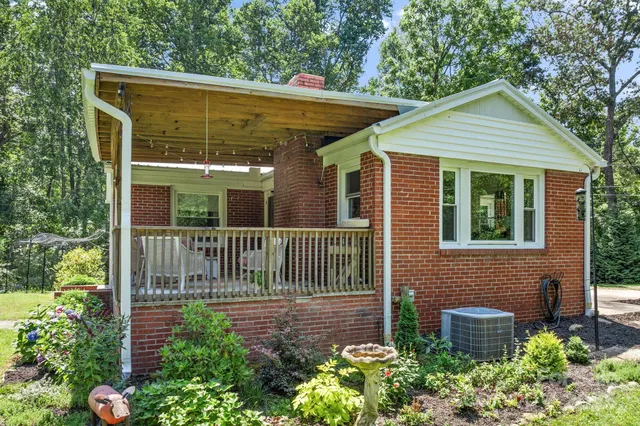 a view of a brick house with a flower garden