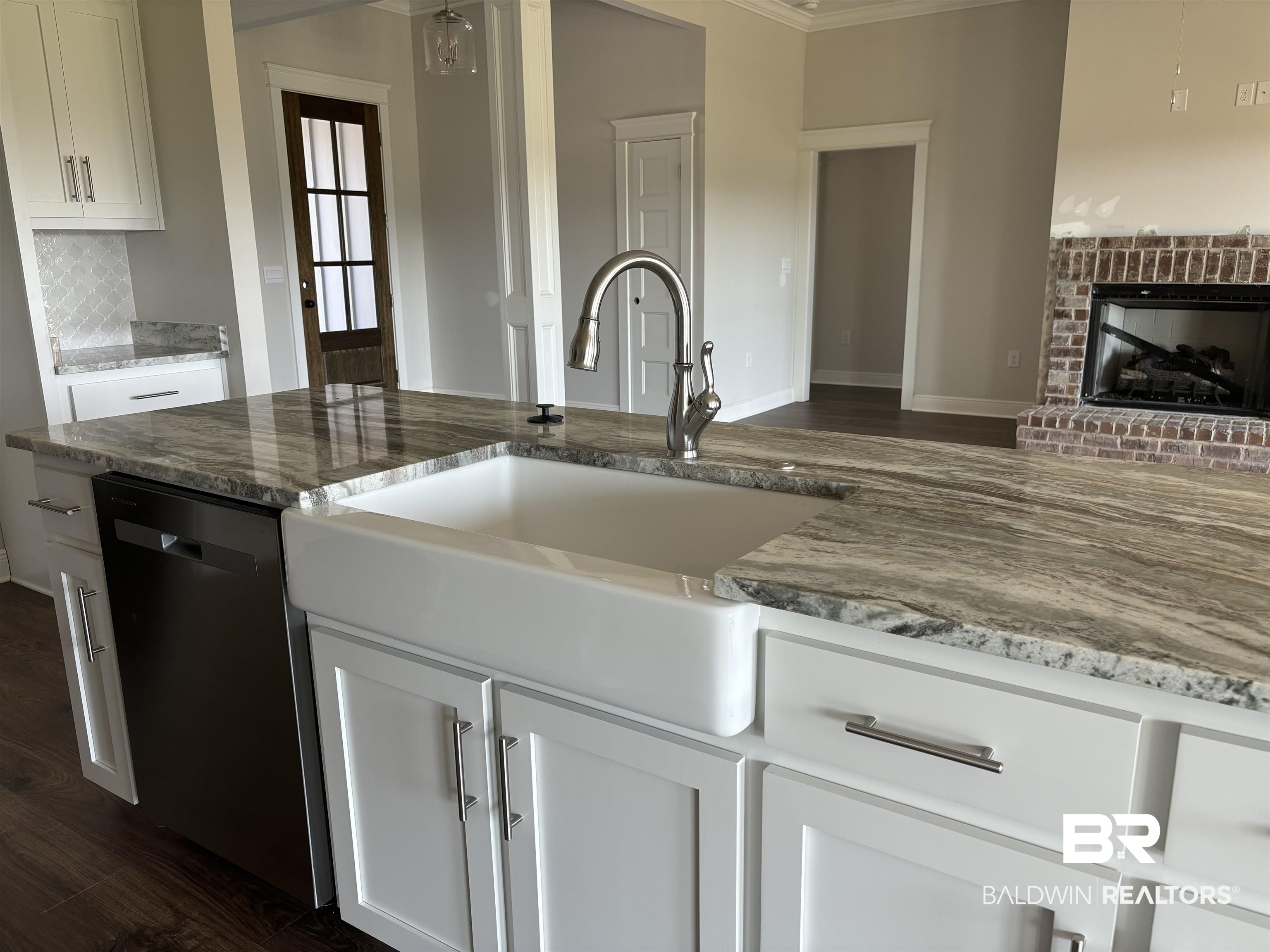 388 Garrison Boulevard Fairhope, AL 36532 - Photo 12 of 34 Kitchen featuring dishwasher, a brick fireplace, dark hardwood / wood-style floors, and light stone counters