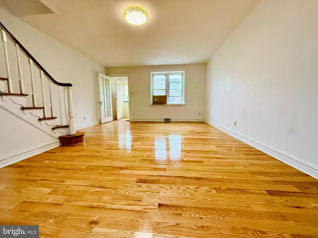 a view of an empty room with wooden floor