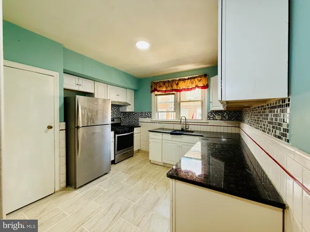 a kitchen with a sink a refrigerator and cabinets