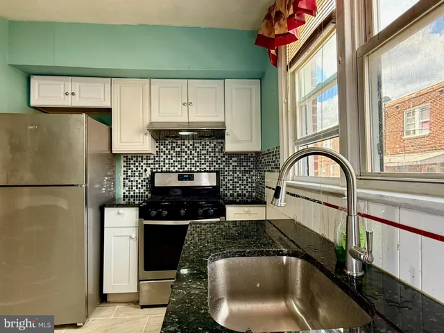 a kitchen with stainless steel appliances granite countertop a stove a sink and a refrigerator
