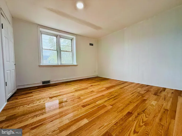 a hallway with wooden floor and furniture
