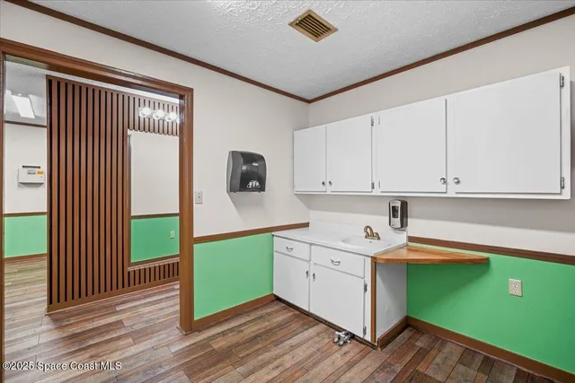 a kitchen with green cabinets and a window