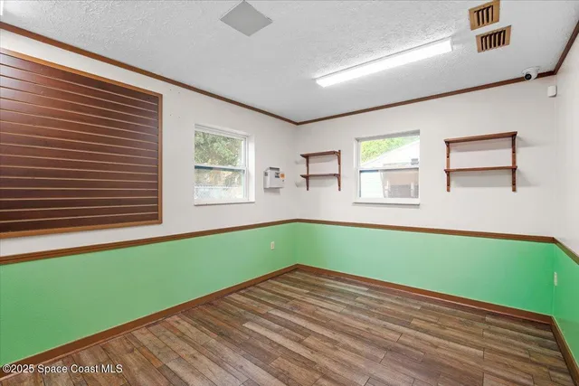 a view of a kitchen with wooden floor and electronic appliances