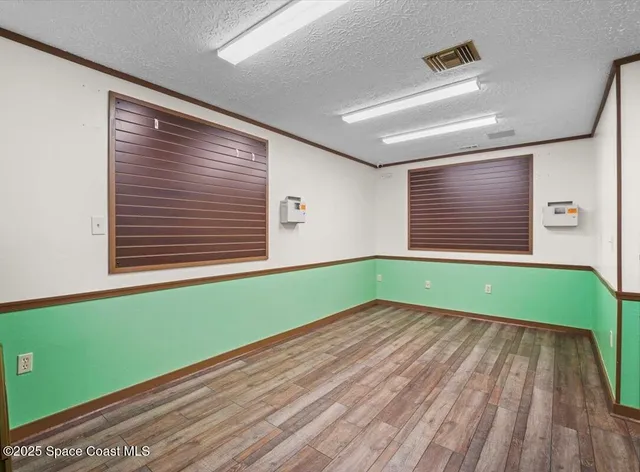 a kitchen with green walls and hard wood floors