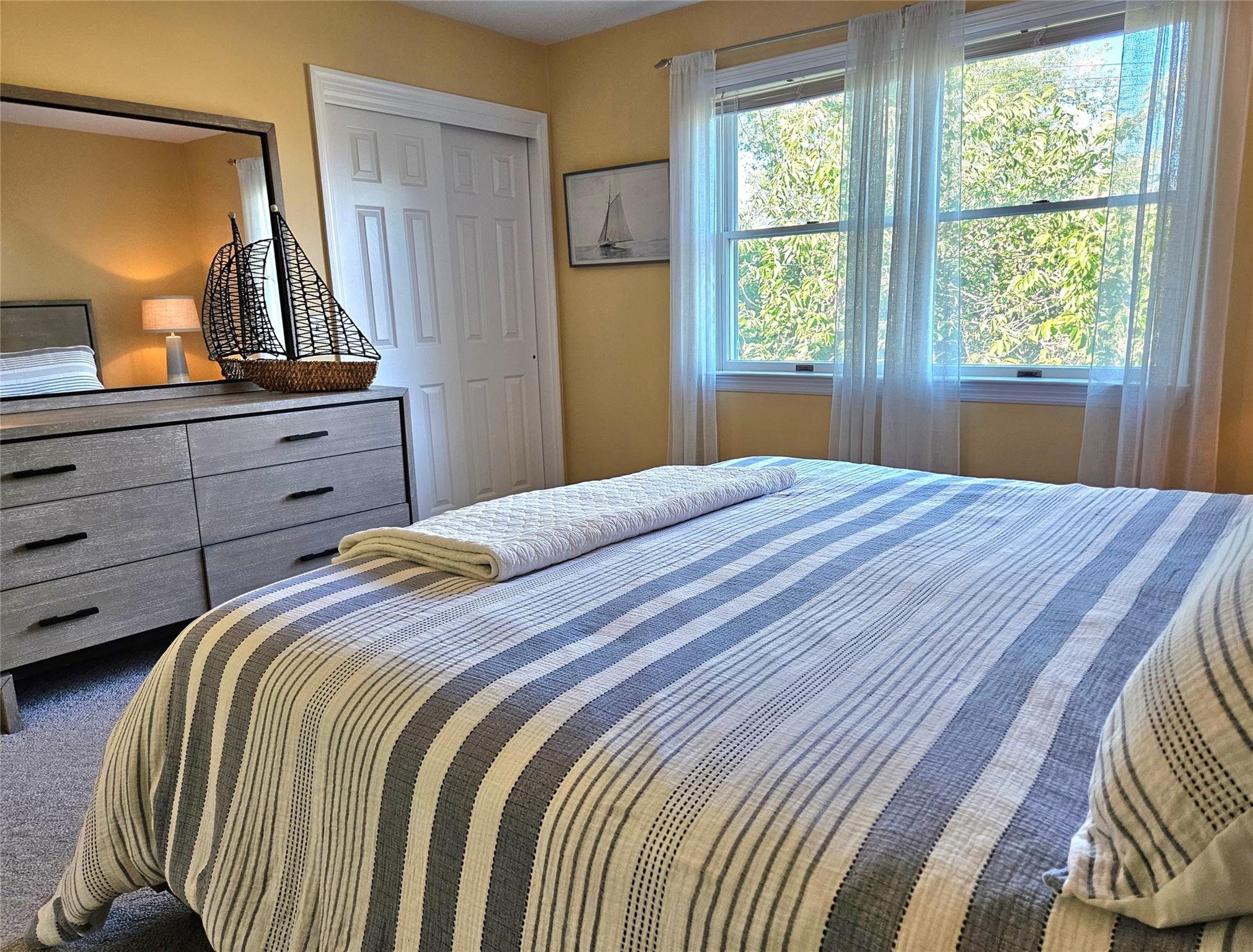3650 Bay Shore Road Greenport, NY 11944 - Photo 24 of 30 a bedroom with a bed and a dresser with mirror