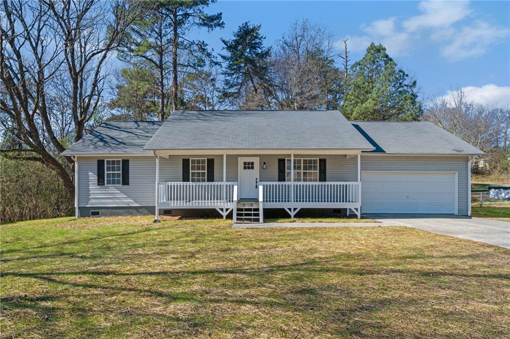 a front view of a house with a yard and trees