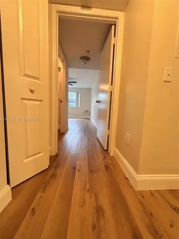 a view of a hallway with wooden floor and staircase