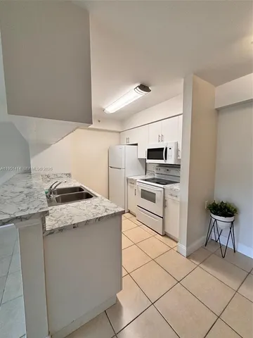 a kitchen with a stove a refrigerator and cabinets