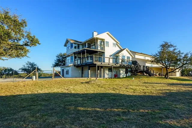 a view of a house next to a big yard with large trees