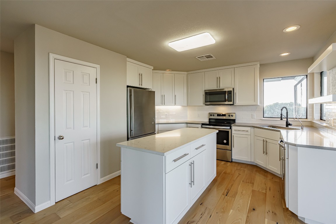 Undisclosed Address Dripping Springs, TX 78620 - Photo 5 of 19 a kitchen with white cabinets and stainless steel appliances