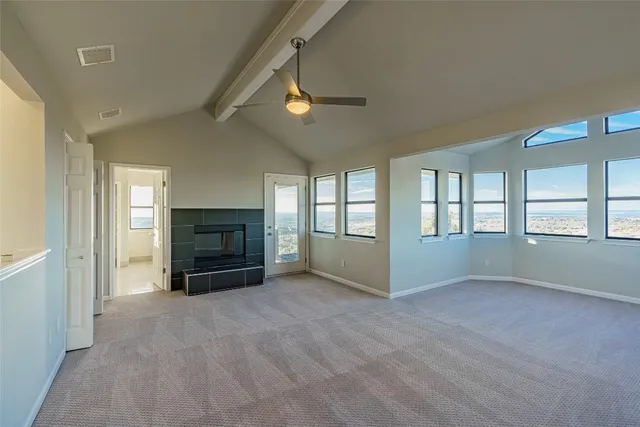 a view of empty room with a fireplace and a window
