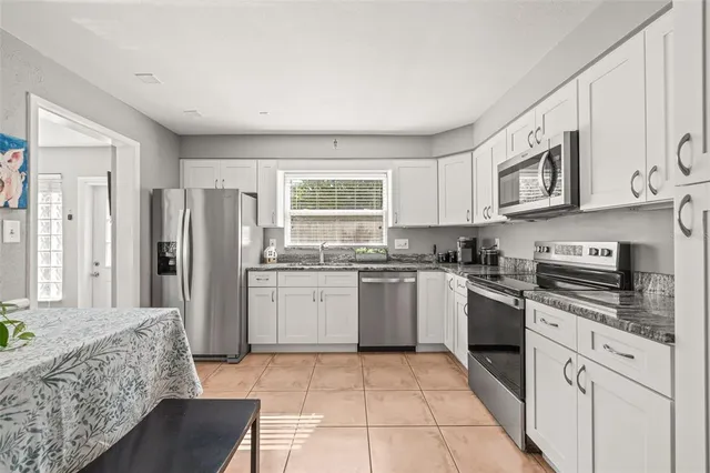 a kitchen with stainless steel appliances granite countertop a stove sink and cabinets
