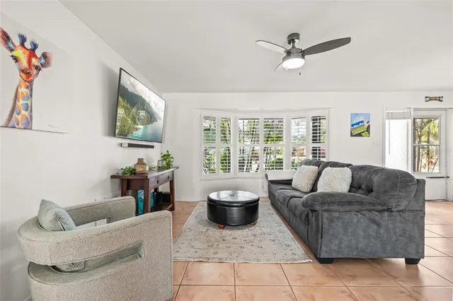 a living room with furniture and a dining table with kitchen view