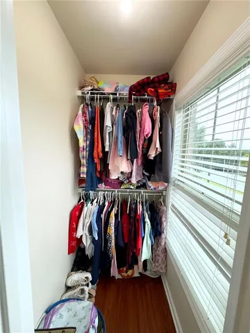 a view of walk in closet with clothes and shoes