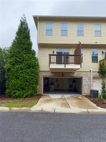 front view of a house with a yard and potted plants