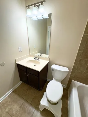 a bathroom with a sink vanity mirror and toilet