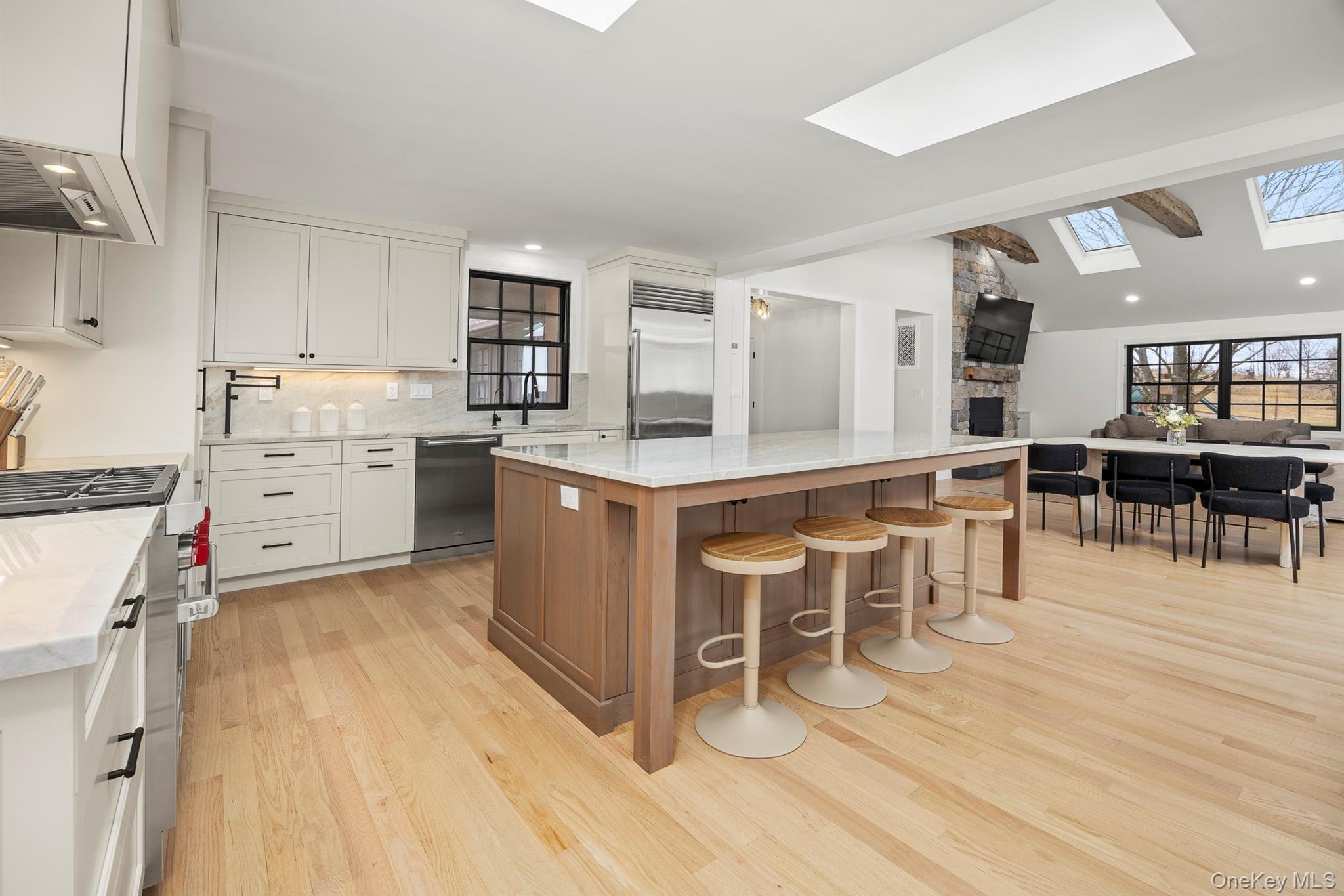 97 Valley Farm Road Millbrook, NY 12545 - Photo 50 of 50 Kitchen featuring a skylight, open floor plan, and light stone counters and counter splash.