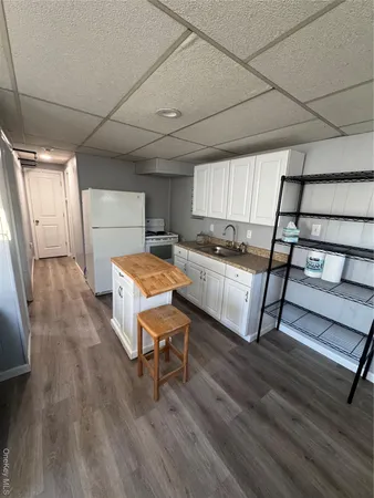 a kitchen with a sink a window and wooden floor