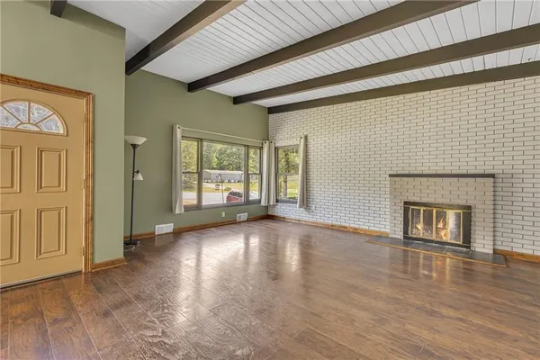 a view of a livingroom with wooden floor and a fireplace