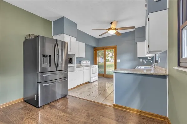 a kitchen with stainless steel appliances a refrigerator sink and white cabinets