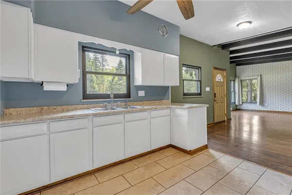 a kitchen with granite countertop white cabinets and window