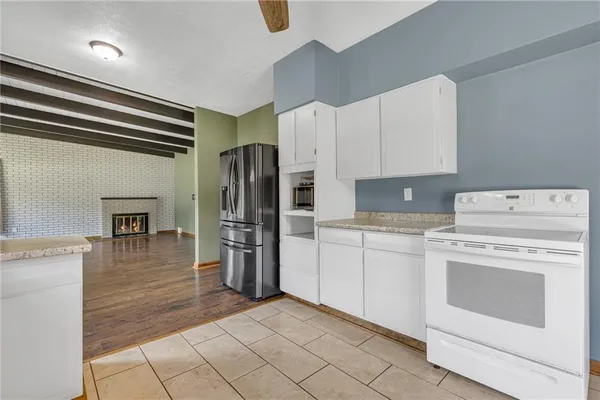a kitchen with a refrigerator sink and cabinets