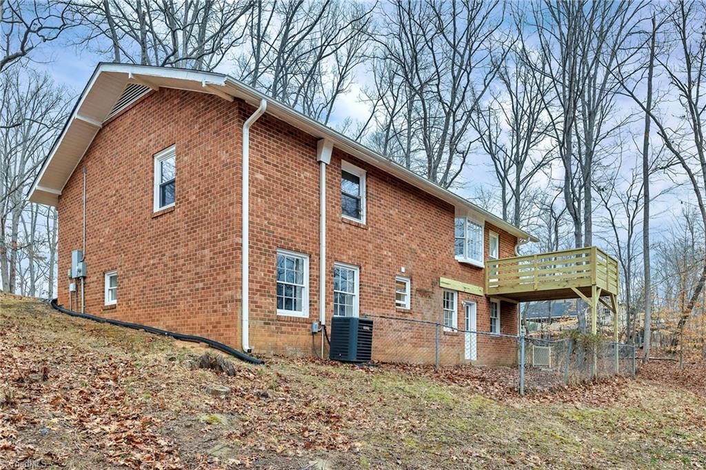 795 Dan Valley Road Madison, NC 27025 - Photo 15 of 38 Rear Left View: Here we can see the low maintenance brick exterior and the new deck.