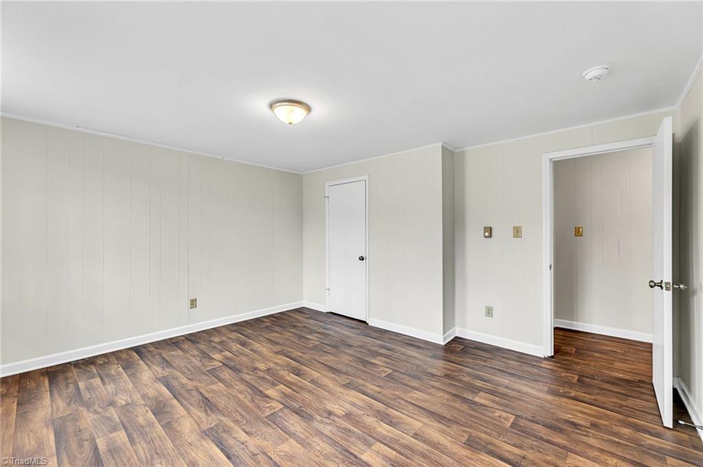 795 Dan Valley Road Madison, NC 27025 - Photo 29 of 38 Basement Game Room: Features include new vinyl plank flooring for easy cleaning, 2 windows for natural lighting and fresh paint. The closet is in the middle and the entry door is to the right side. You do pick up some extra floor space by the closet.