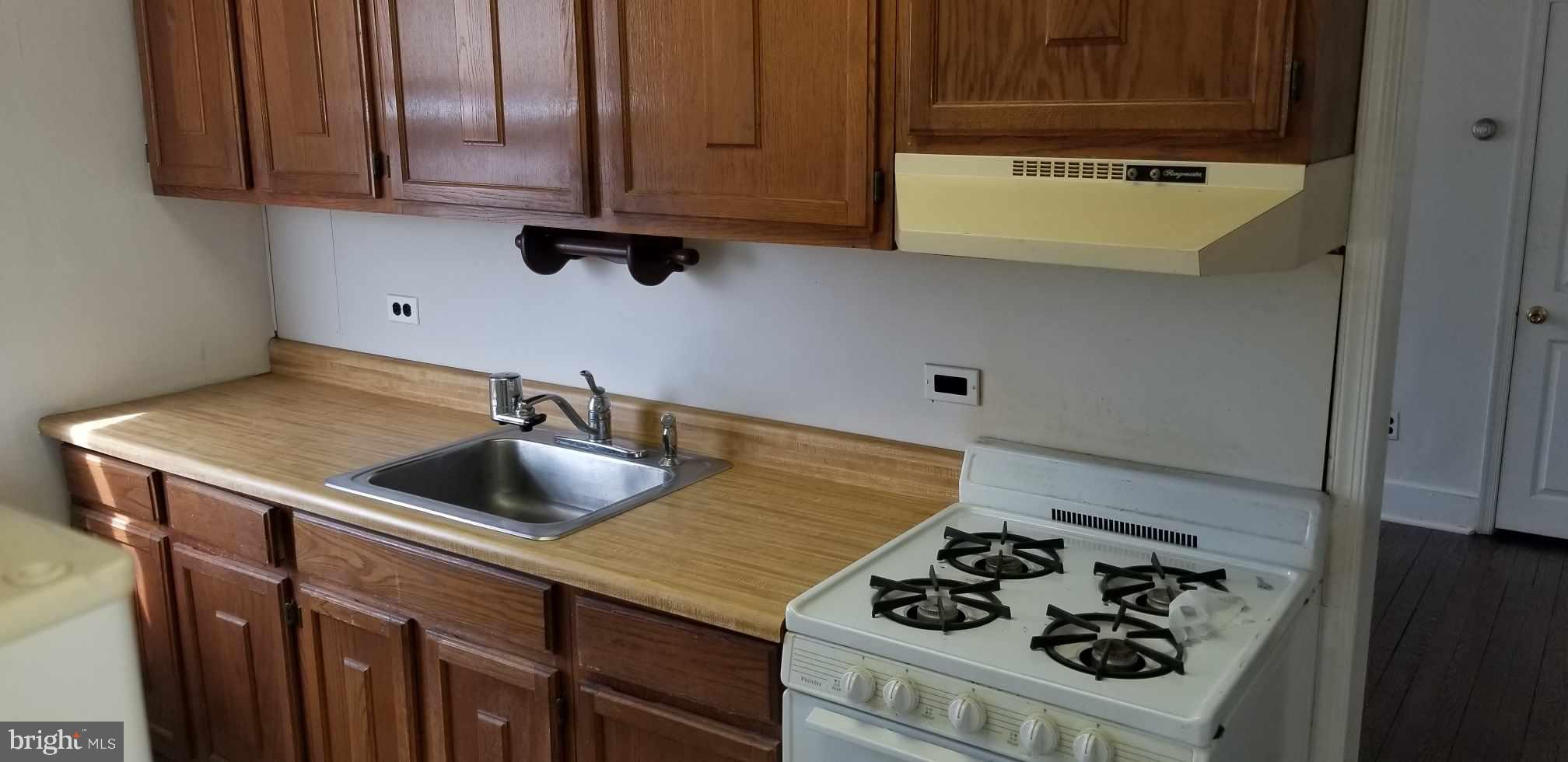 a kitchen with a sink a stove and cabinets