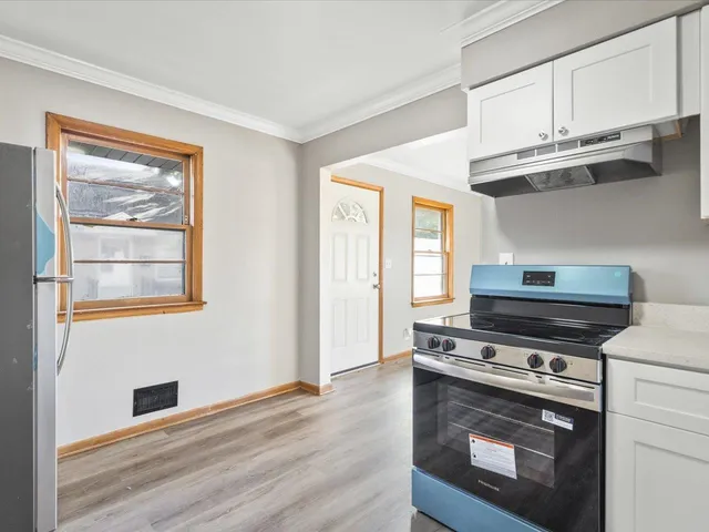 a kitchen with wooden floor and steel stainless steel appliances