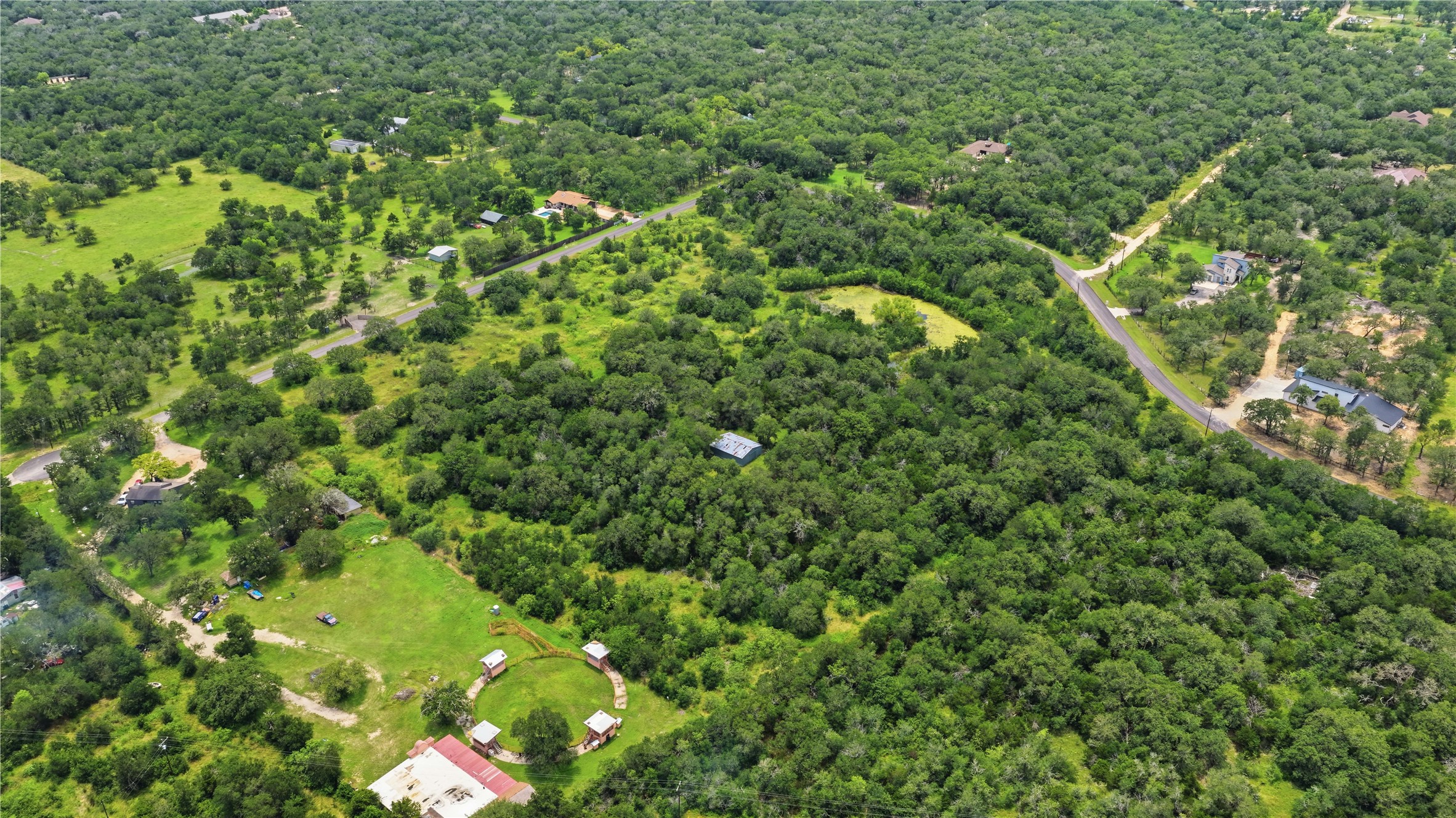 10312 Parsons Road Manor, TX 78653 - Photo 8 of 26 An aerial panorama reveals a vast, verdant estate with natural ponds and scenic roadways.