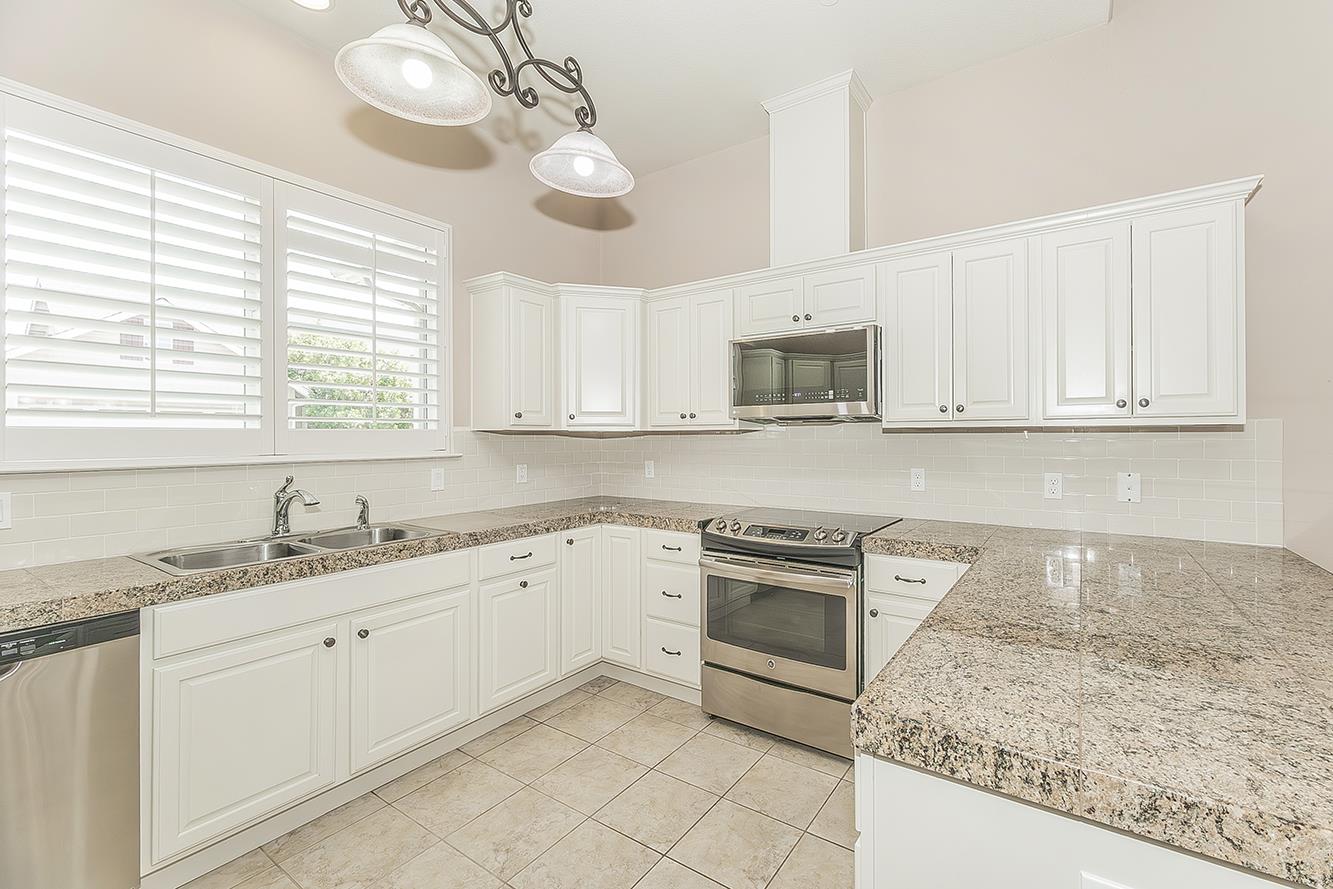 2047 South Church Avenue Reedley, CA 93654 - Photo 11 of 39 a kitchen with granite countertop white cabinets white stainless steel appliances a sink and a window