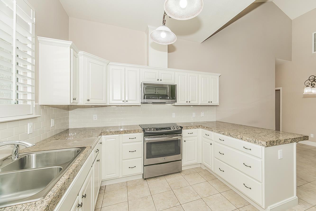 2047 South Church Avenue Reedley, CA 93654 - Photo 12 of 39 a kitchen with granite countertop white cabinets white stainless steel appliances with a sink and dishwasher