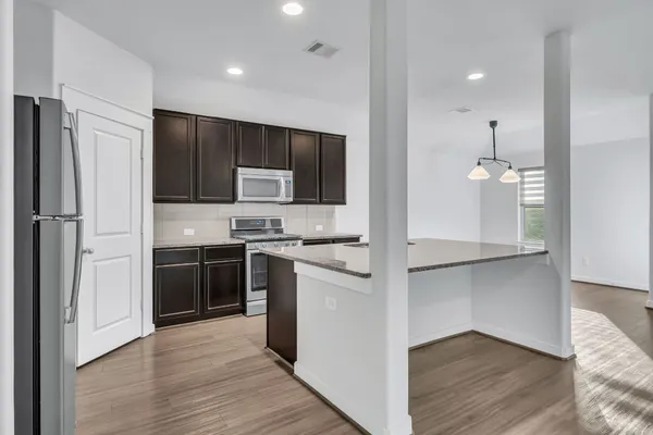 a kitchen with kitchen island a counter space a sink appliances and cabinets