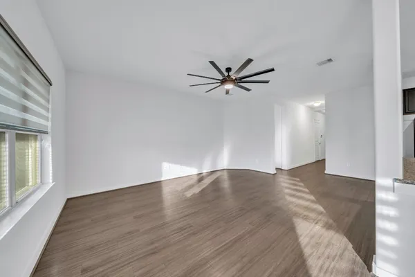a view of a big room with wooden floor and a window