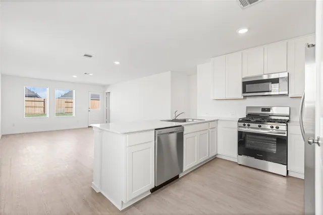 a kitchen with stainless steel appliances granite countertop a stove a sink and a refrigerator