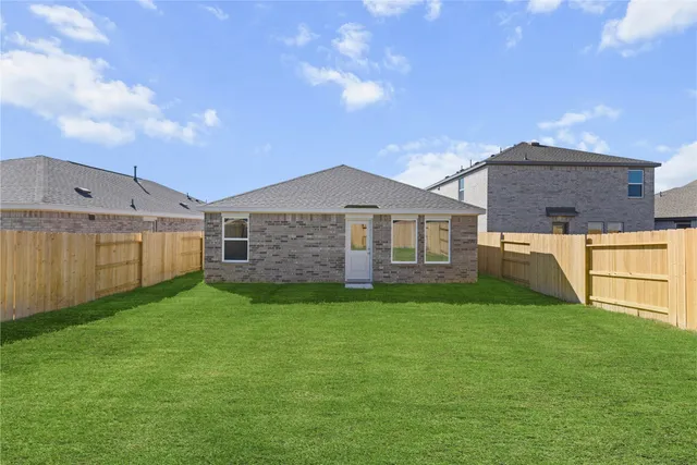 a view of a yard in front of a house with garage and plants