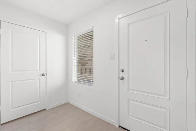 a view of an empty room with closet and a window
