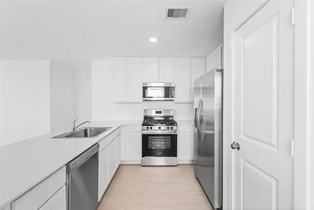 a kitchen with a sink and stainless steel appliances
