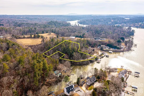 an aerial view of a house with a yard and lake view