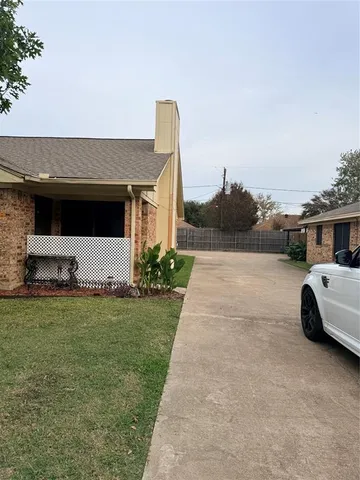 a view of house with backyard and parking