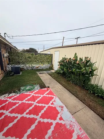 a view of an empty room with a fireplace and a chandelier fan