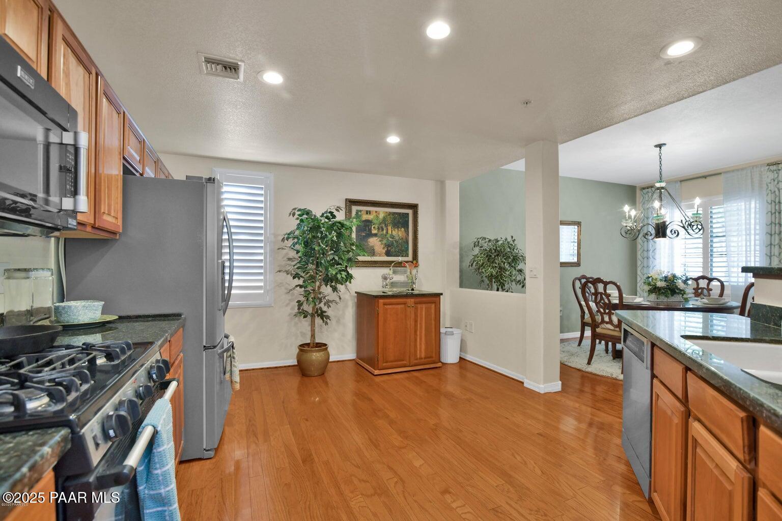 1716 Alpine Meadows Lane, Unit 1007 Prescott, AZ 86303 - Photo 6 of 21 a kitchen with kitchen island a counter top space a sink stainless steel appliances and cabinets