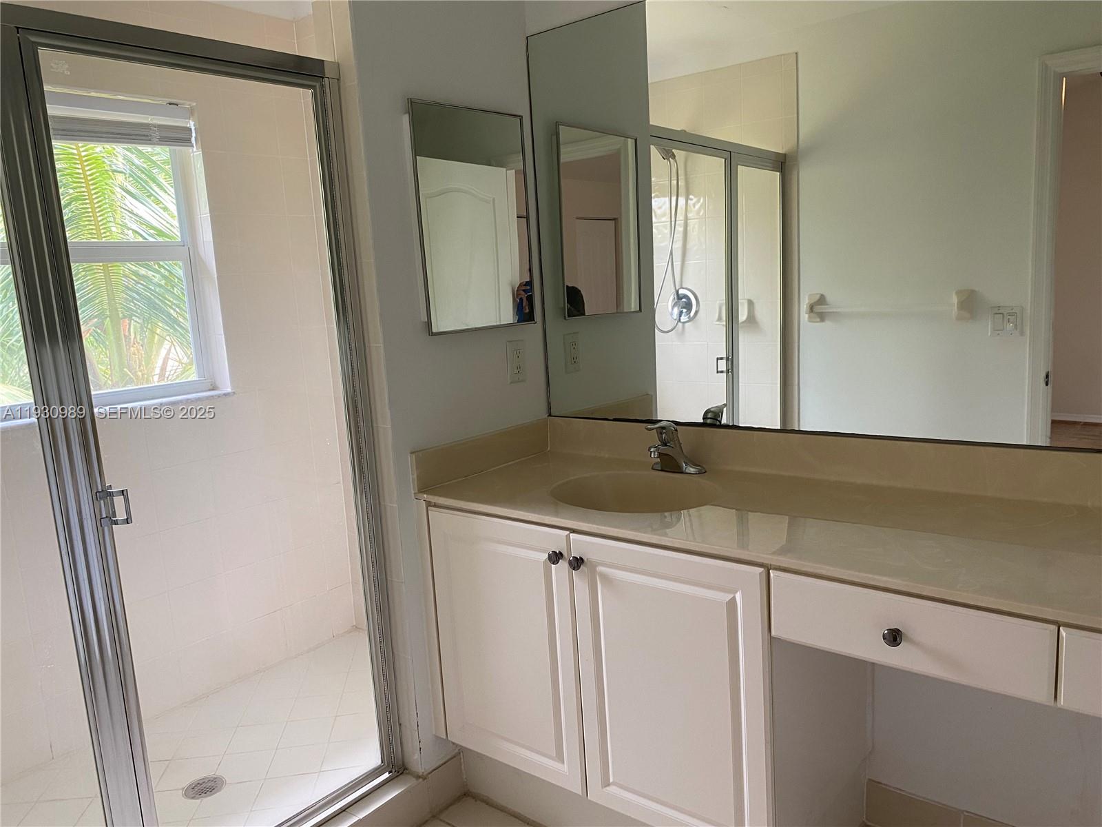 112 Wakulla Springs Way, Unit 112 Royal Palm Beach, FL 33411 - Photo 12 of 20 a bathroom with a granite countertop sink a mirror and a shower