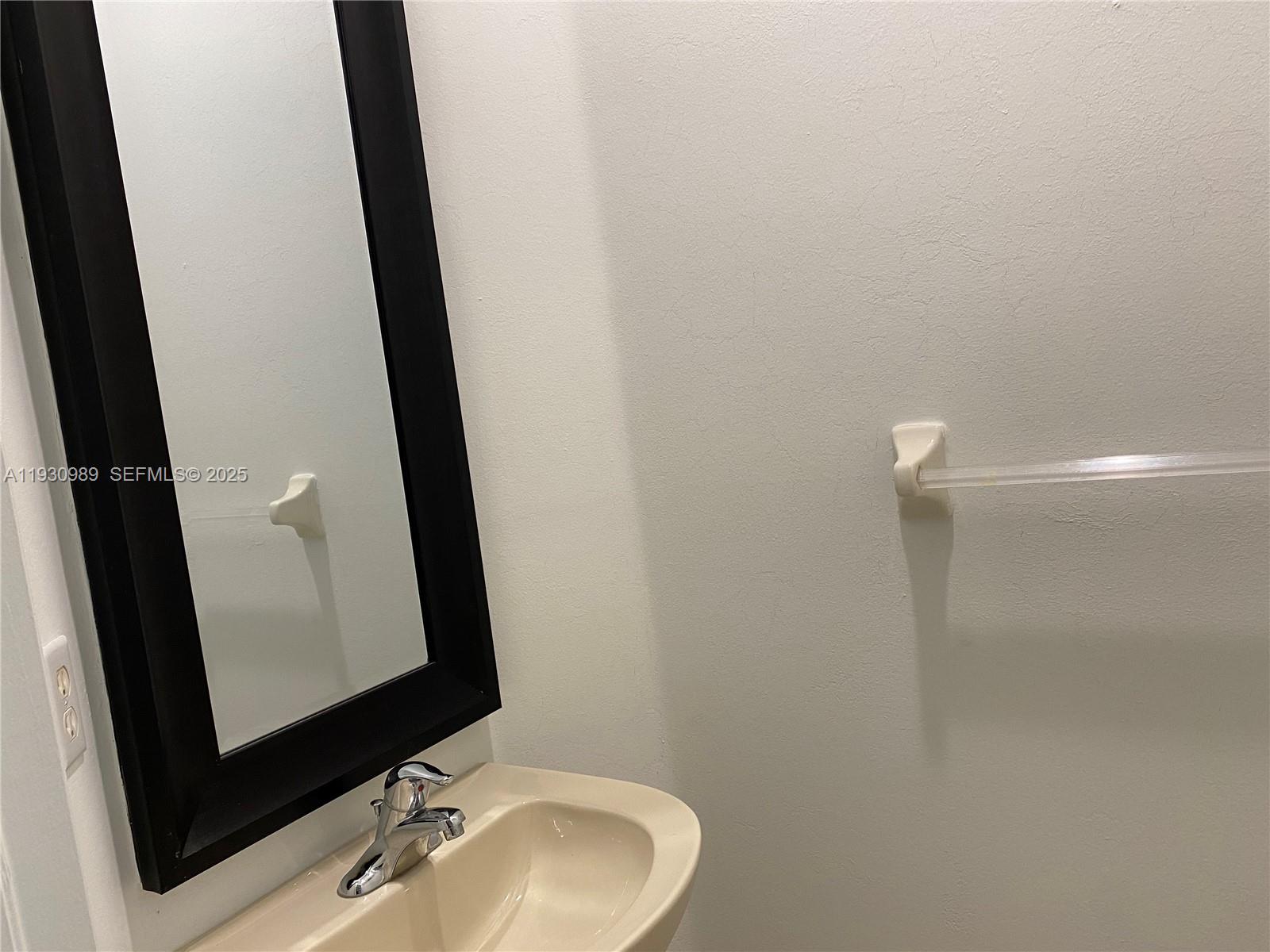 112 Wakulla Springs Way, Unit 112 Royal Palm Beach, FL 33411 - Photo 19 of 20 a bathroom with a sink and a mirror