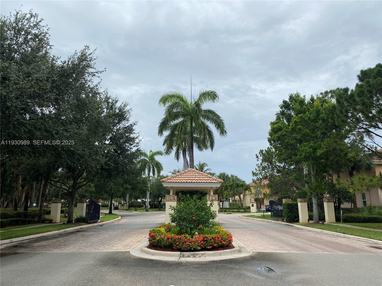 112 Wakulla Springs Way, Unit 112 Royal Palm Beach, FL 33411 - Photo 20 of 20 a view of a street with a fountain and large trees